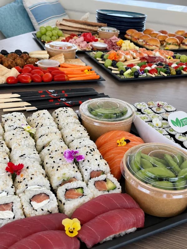 Sushi rolls and tuna nigiri in front of sharing platters laid out on a yacht